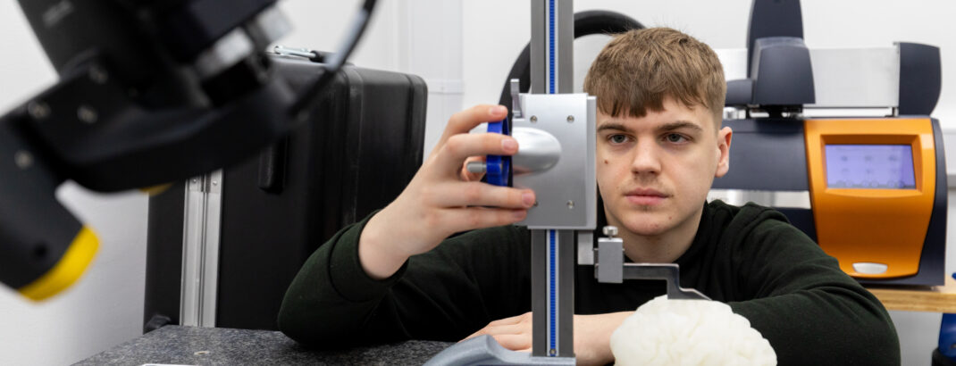 Junior Engineer, Charlie Kelsey, in one of the Ricoh 3D laboratory suites, measuring a 3D-printed brain model.