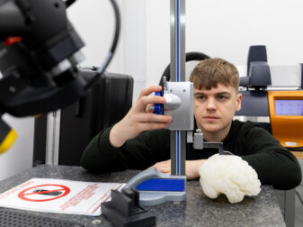 Junior Engineer, Charlie Kelsey, in one of the Ricoh 3D laboratory suites, measuring a 3D-printed brain model.